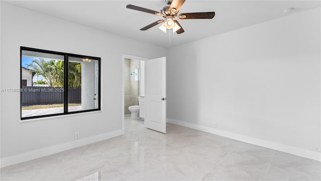 unfurnished bedroom featuring ceiling fan and ensuite bath