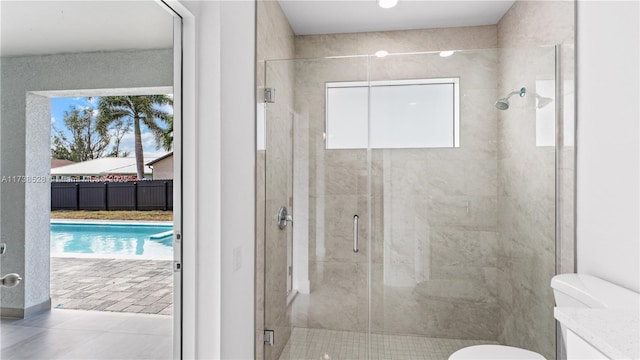 bathroom featuring an enclosed shower, vanity, tile patterned flooring, and toilet