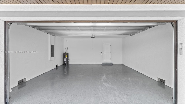 garage featuring electric panel and water heater