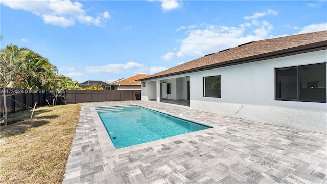 view of pool with a patio and a lawn