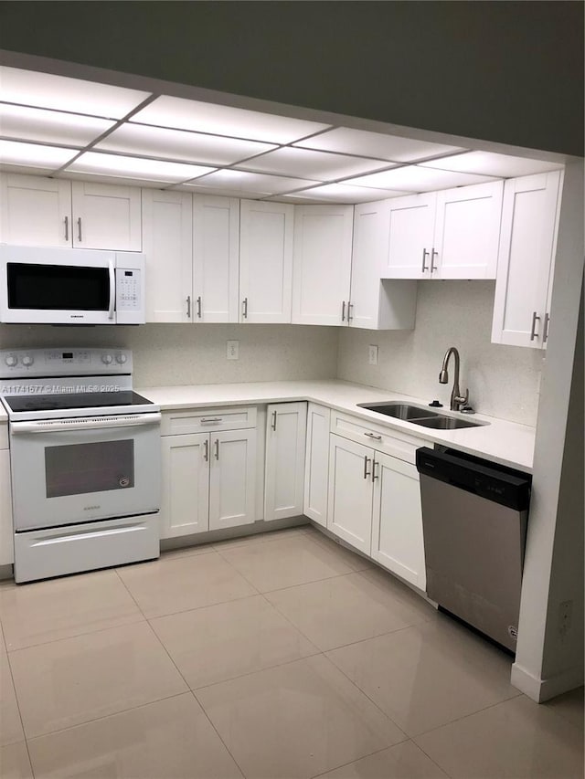 kitchen with backsplash, white appliances, sink, and white cabinets