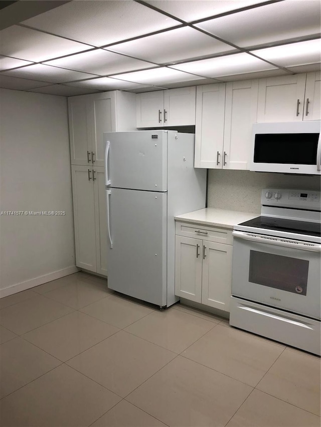 kitchen featuring white cabinetry, white appliances, and light tile patterned flooring