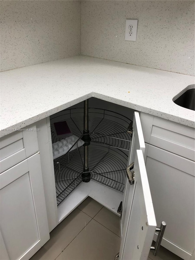 room details featuring white cabinetry and light stone countertops