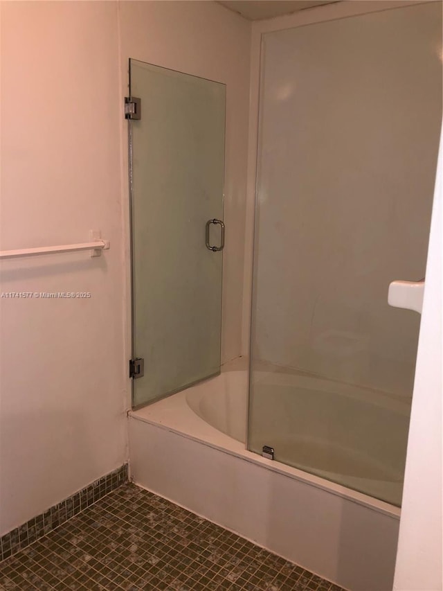 bathroom with tile patterned flooring and bath / shower combo with glass door