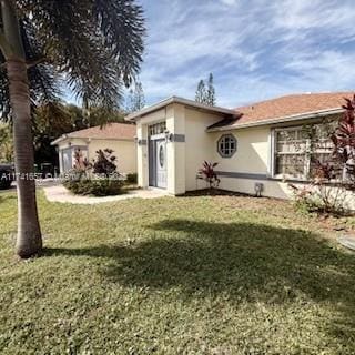 view of front of home featuring a front yard and stucco siding