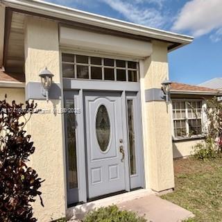 entrance to property with stucco siding