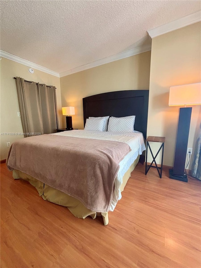 bedroom featuring hardwood / wood-style flooring, crown molding, and a textured ceiling