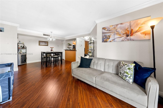 living room featuring crown molding, a notable chandelier, and dark hardwood / wood-style flooring