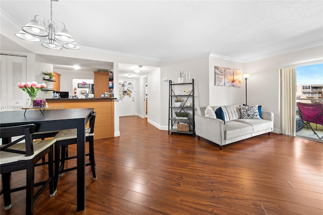 living room with crown molding, dark wood-type flooring, and a chandelier