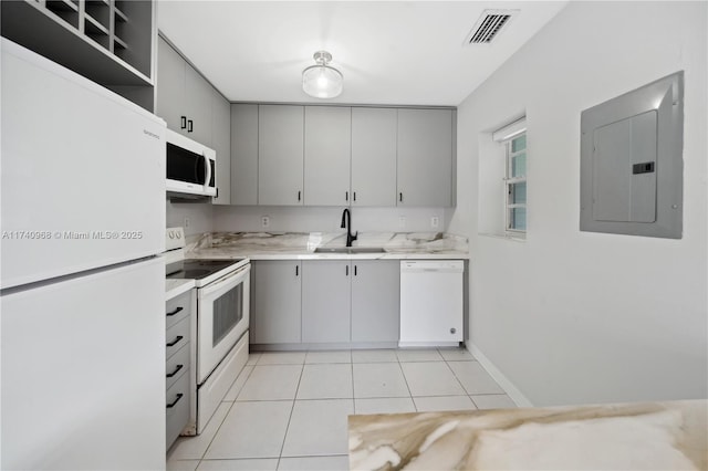 kitchen featuring sink, white appliances, gray cabinets, light tile patterned floors, and electric panel