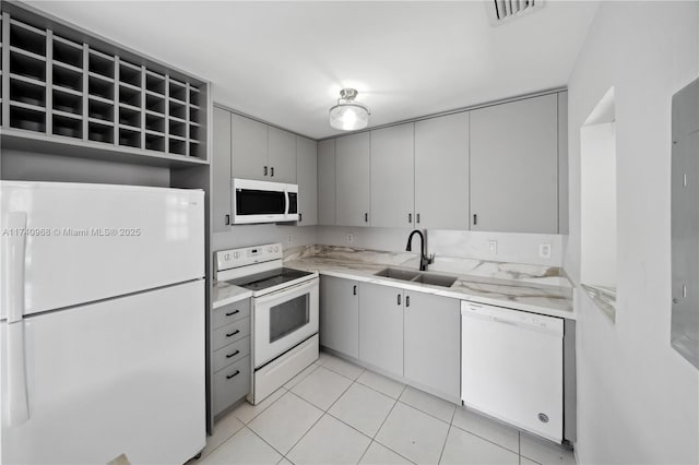 kitchen with sink, gray cabinetry, white appliances, and light tile patterned floors