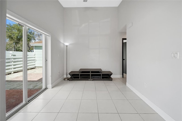 living area with a towering ceiling and light tile patterned floors