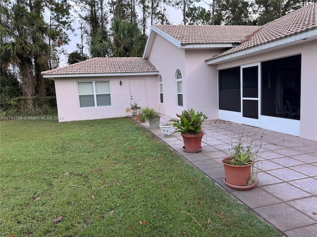 rear view of house with a yard and a patio area