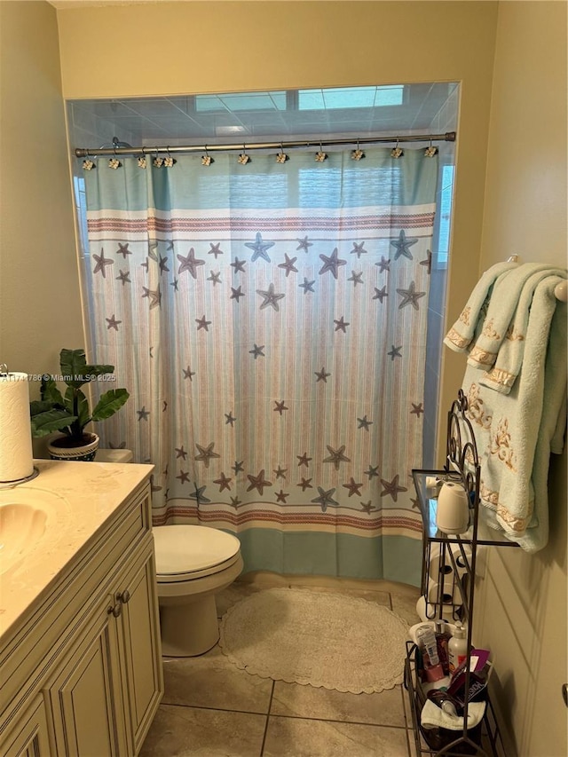 bathroom featuring tile patterned flooring, vanity, walk in shower, and toilet