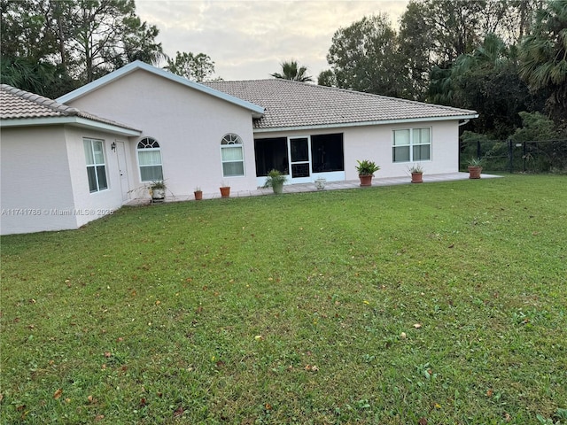 rear view of house featuring a yard