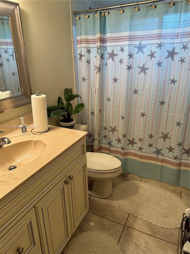 bathroom featuring walk in shower, vanity, toilet, and tile patterned flooring