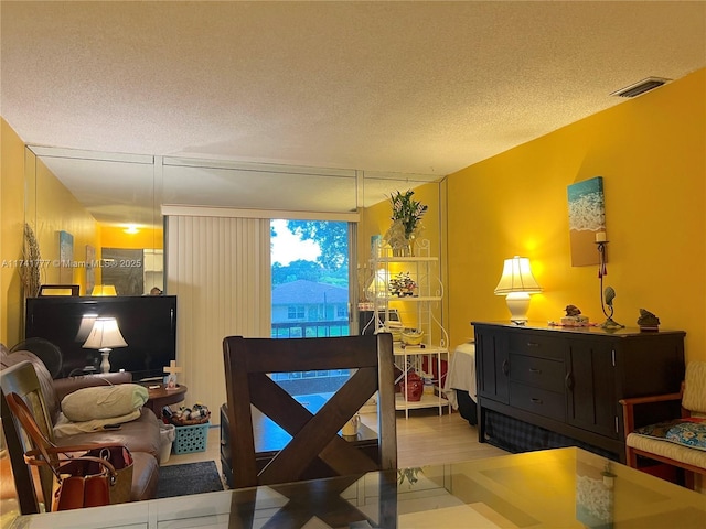 dining space featuring hardwood / wood-style floors and a textured ceiling