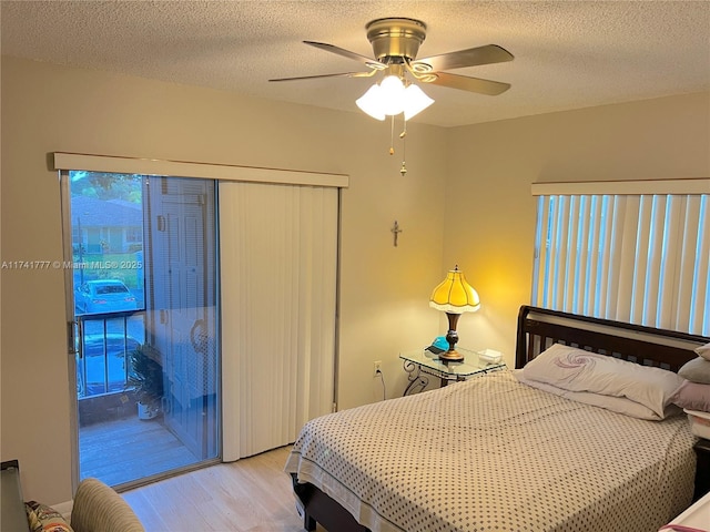 bedroom featuring ceiling fan, light hardwood / wood-style flooring, a textured ceiling, and access to exterior