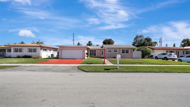 single story home featuring a garage and a front lawn