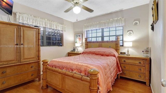 bedroom with light hardwood / wood-style floors and ceiling fan