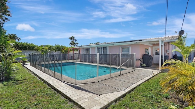 view of swimming pool with a lawn