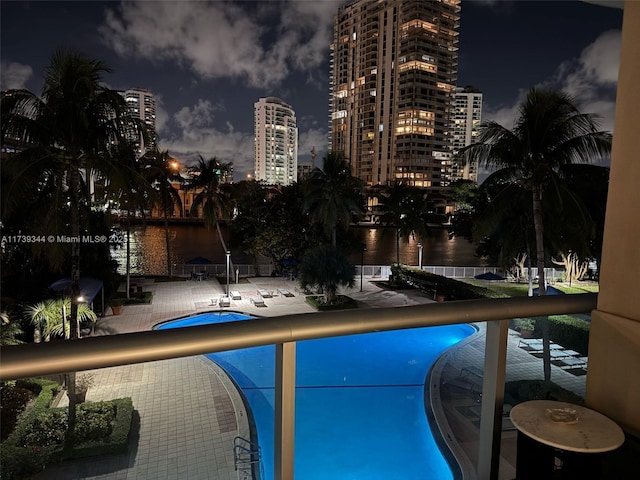 view of swimming pool with a water view and a patio