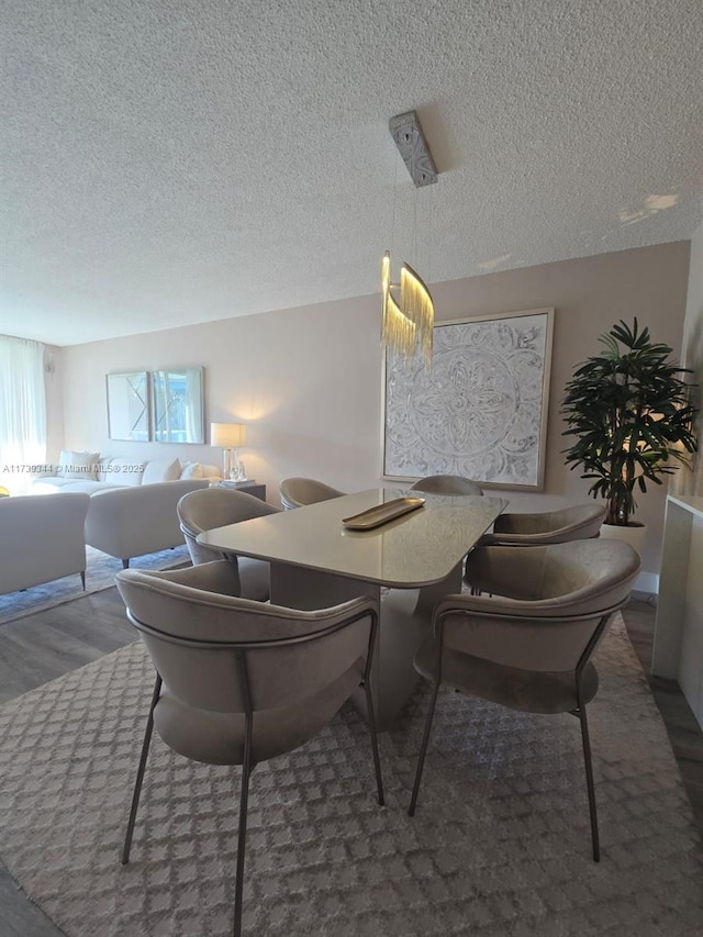 dining area featuring dark hardwood / wood-style flooring and a textured ceiling