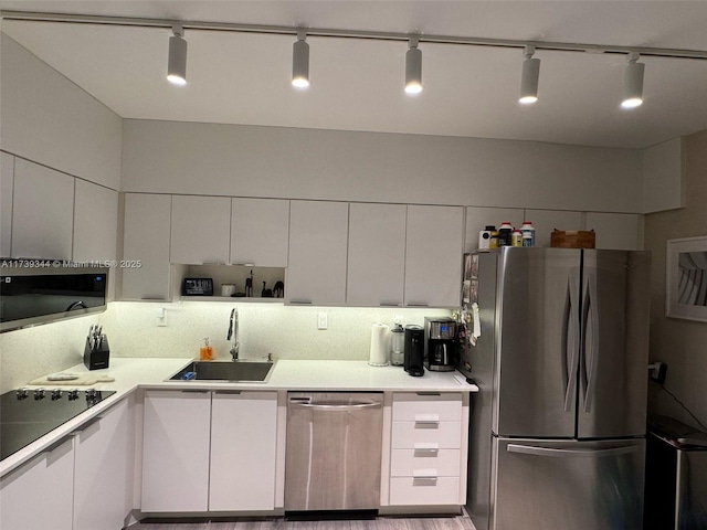 kitchen featuring appliances with stainless steel finishes, sink, and white cabinets