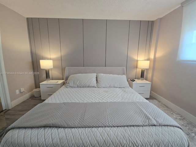 bedroom featuring wood-type flooring and a textured ceiling