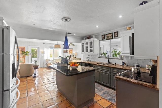 kitchen with sink, crown molding, appliances with stainless steel finishes, white cabinets, and a kitchen island