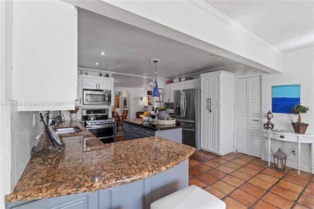 kitchen featuring sink, crown molding, white cabinetry, stainless steel appliances, and kitchen peninsula