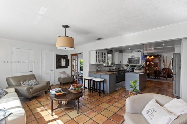 living room with ornamental molding, sink, and a textured ceiling