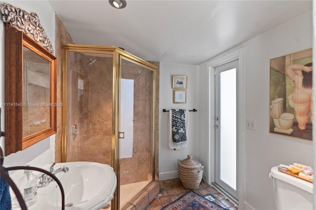 bathroom with sink, tile patterned floors, toilet, and walk in shower