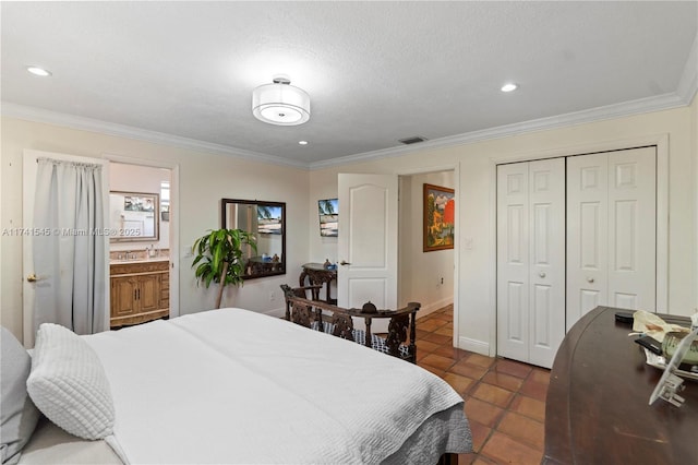 bedroom featuring ensuite bathroom, a textured ceiling, ornamental molding, a closet, and dark tile patterned floors