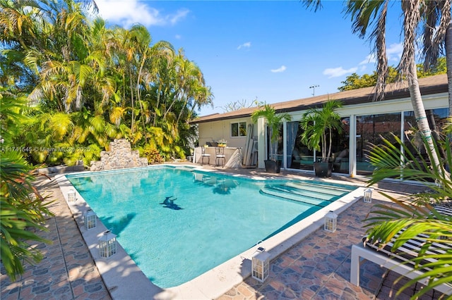 view of swimming pool with exterior bar and a patio area