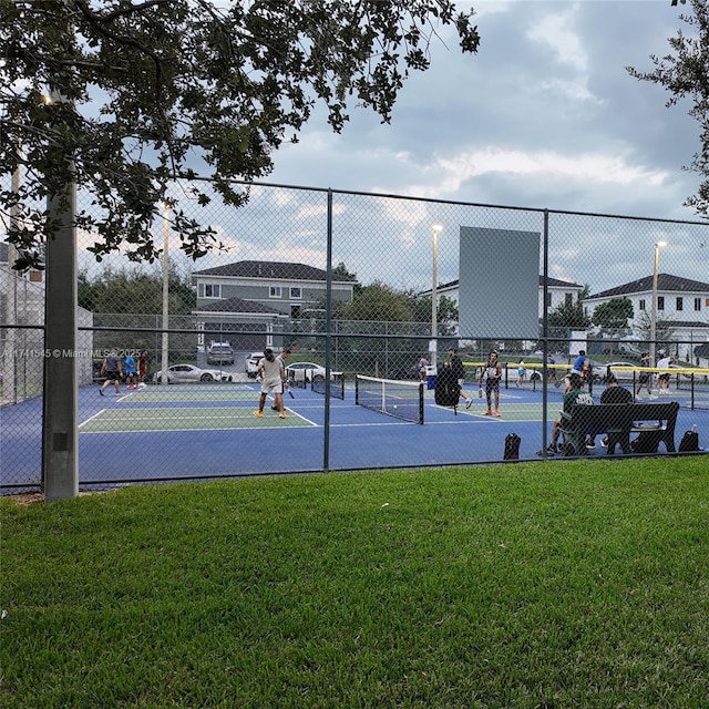 view of tennis court featuring a yard