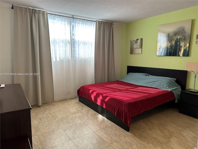 bedroom with a textured ceiling and light tile patterned floors