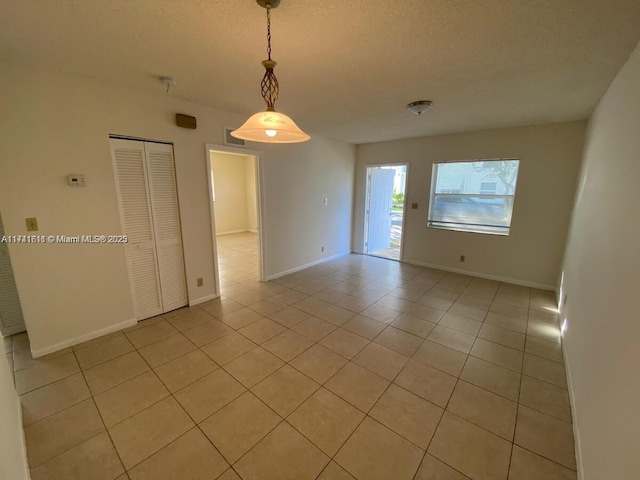 unfurnished room featuring light tile patterned floors and a textured ceiling