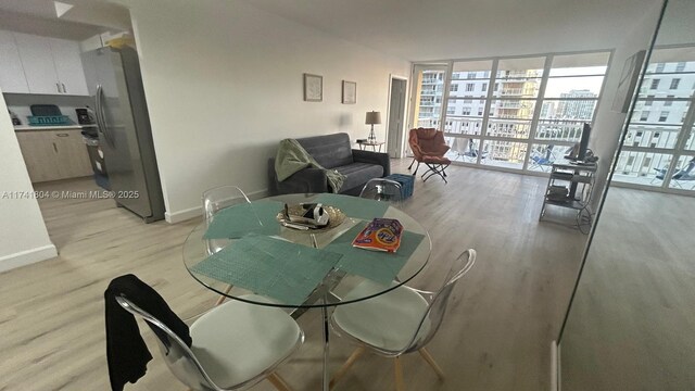 dining room featuring expansive windows and light hardwood / wood-style flooring