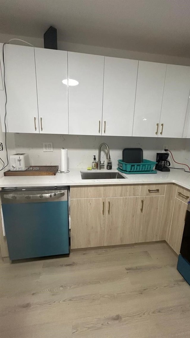 kitchen with sink, range, light brown cabinets, light wood-type flooring, and dishwashing machine