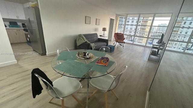 dining room featuring expansive windows and light wood-type flooring