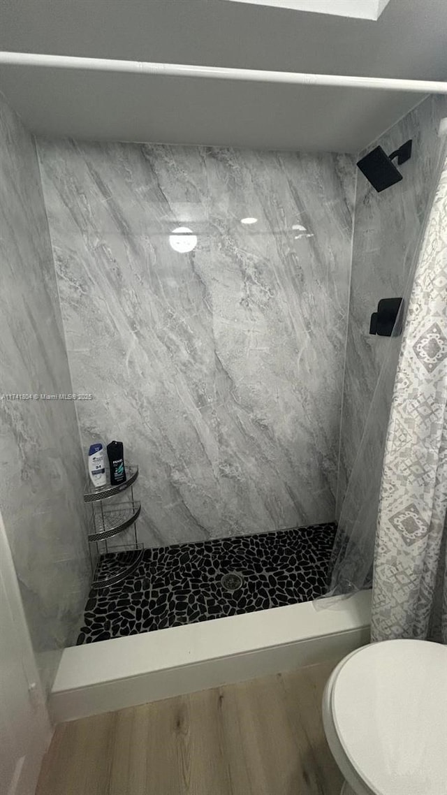 bathroom featuring toilet and tiled shower