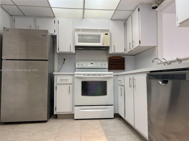 kitchen featuring a drop ceiling, white cabinets, stainless steel appliances, and light countertops