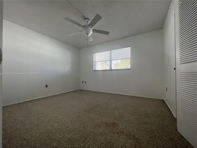 carpeted empty room featuring ceiling fan, baseboards, and a textured ceiling