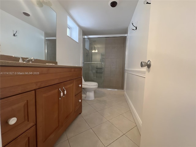 full bath with tile patterned flooring, a stall shower, toilet, and vanity