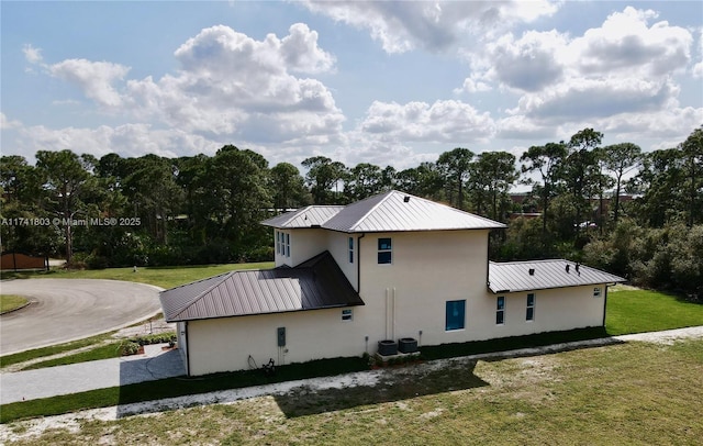 view of home's exterior featuring a lawn and central air condition unit