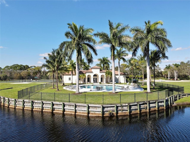 exterior space with a water view, a yard, a fenced in pool, and a patio