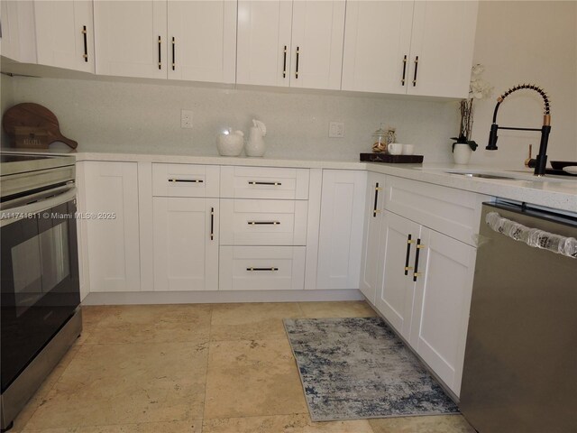 1316 SW 118th Ter Unit 1316, Davie, FL 33325 - kitchen featuring a sink, backsplash, white cabinetry, appliances with stainless steel finishes, and light countertops