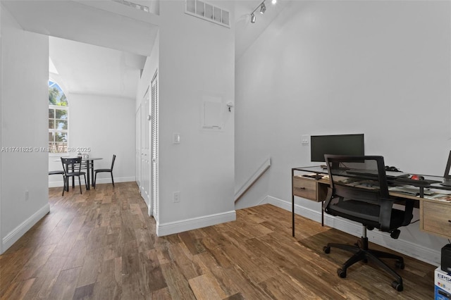 home office featuring wood-type flooring and rail lighting