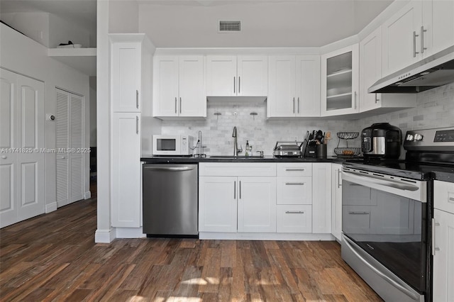 kitchen featuring appliances with stainless steel finishes, ventilation hood, white cabinetry, sink, and dark hardwood / wood-style flooring